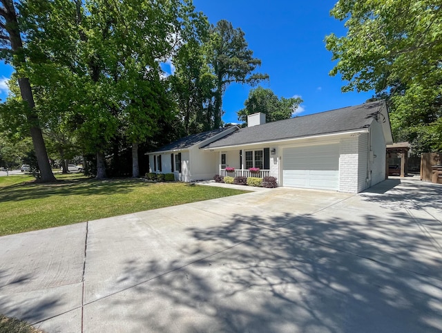 single story home with a garage, driveway, brick siding, a front yard, and covered porch