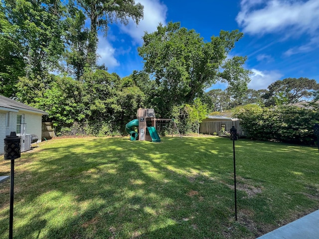 view of yard with a playground and central AC unit