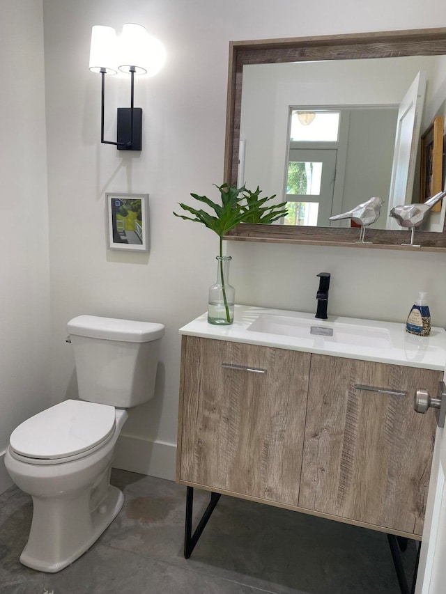 bathroom featuring vanity, toilet, and concrete floors