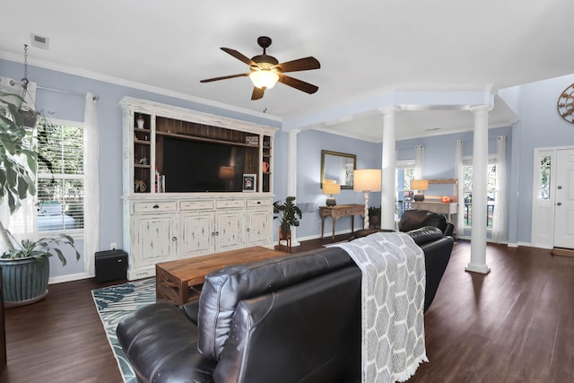 living room featuring baseboards, ornamental molding, a ceiling fan, ornate columns, and dark wood-type flooring