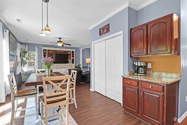 dining room with dark wood-type flooring, visible vents, a ceiling fan, and crown molding