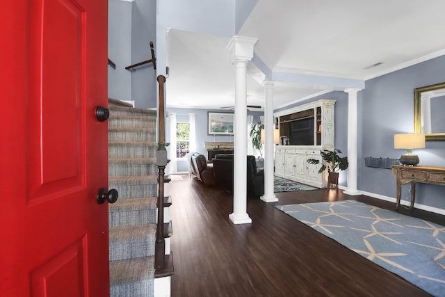 foyer with baseboards, ornamental molding, ornate columns, stairway, and wood finished floors