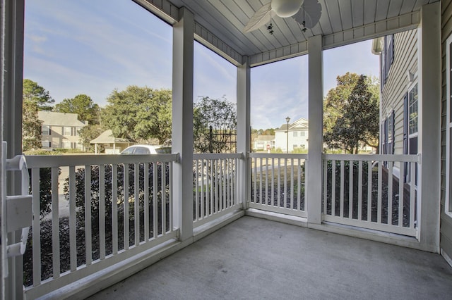 unfurnished sunroom with ceiling fan