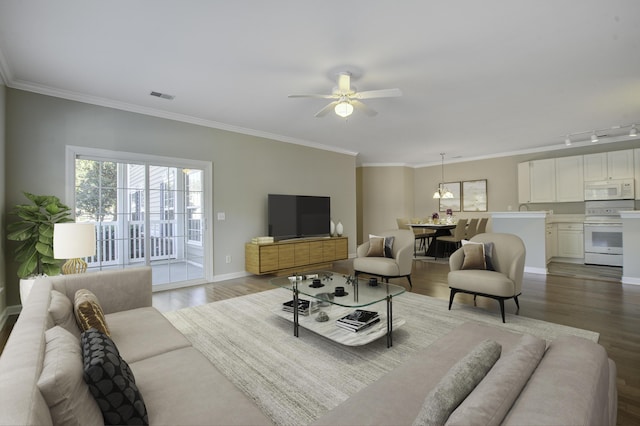 living room featuring hardwood / wood-style floors, track lighting, ceiling fan, and crown molding