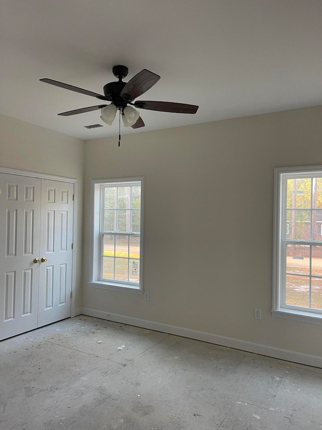 empty room featuring ceiling fan and a wealth of natural light