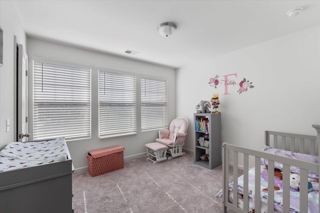 bedroom with visible vents, baseboards, a nursery area, and carpet floors