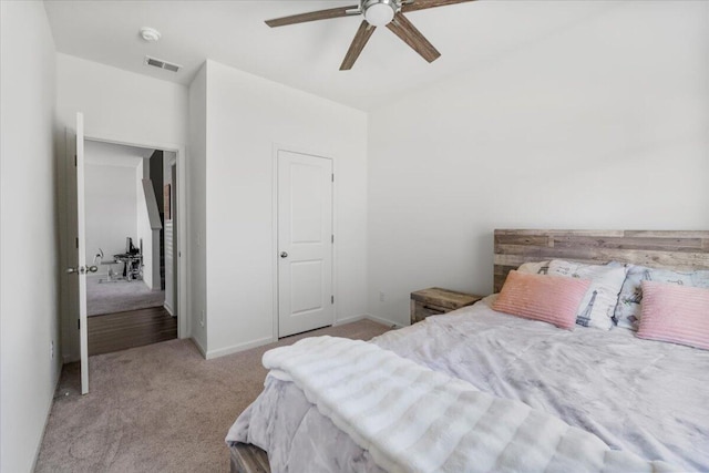 carpeted bedroom with visible vents, baseboards, and ceiling fan