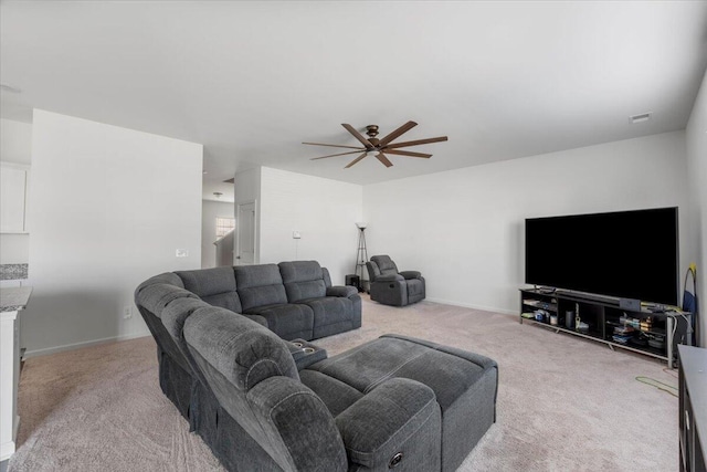 living area with visible vents, carpet floors, baseboards, and a ceiling fan