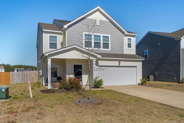 traditional-style house featuring driveway, a front lawn, a garage, and fence