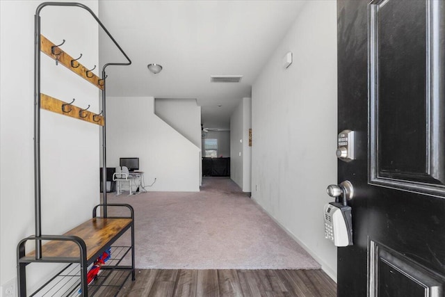 entryway with visible vents, wood finished floors, and carpet flooring