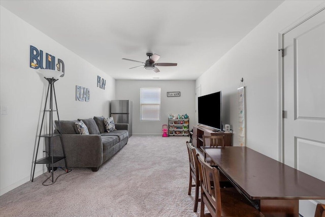 living area with a ceiling fan, carpet, and baseboards