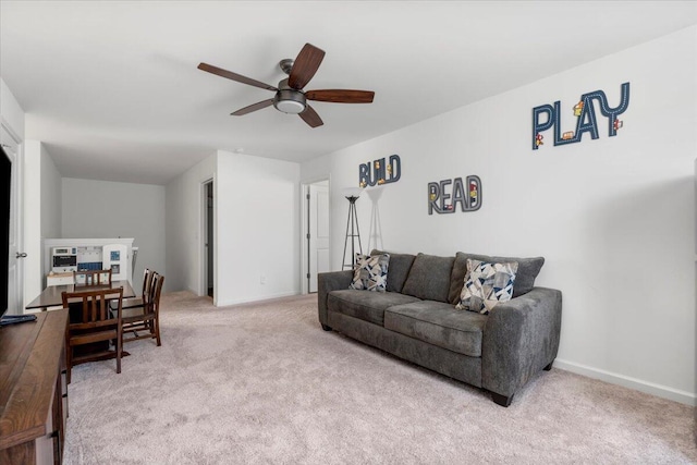 living area featuring baseboards, carpet, and ceiling fan