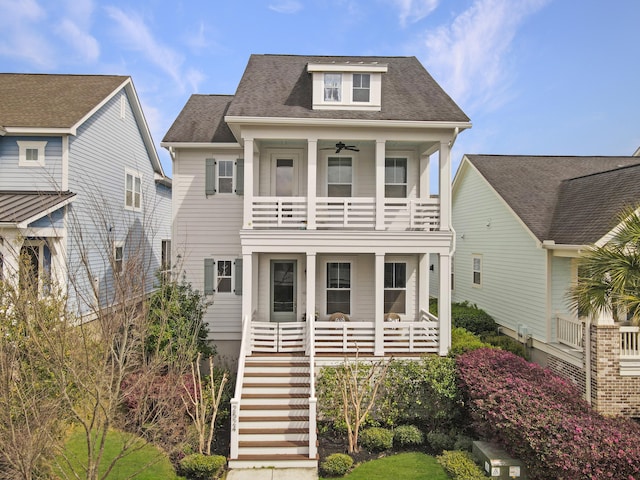 view of front of house featuring ceiling fan, a balcony, stairs, a shingled roof, and a porch