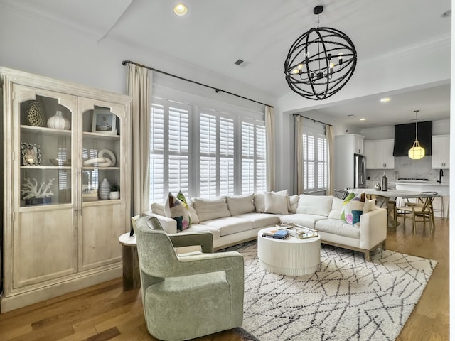 living area with visible vents, recessed lighting, wood finished floors, and a chandelier