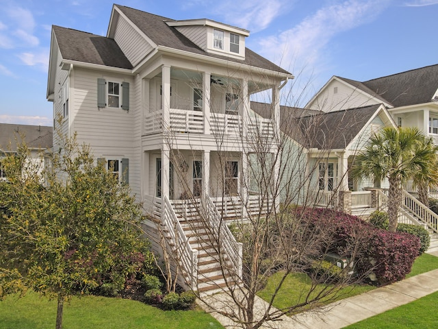 view of front of home featuring a front yard, stairway, and a balcony