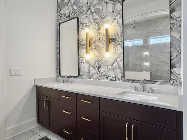 bathroom with a sink, baseboards, walk in shower, and double vanity