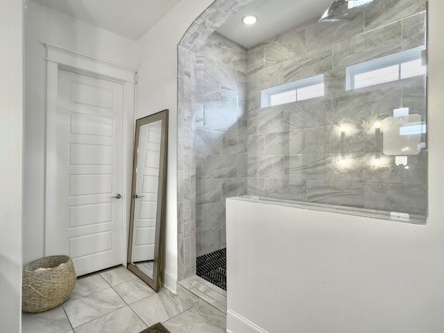 bathroom with marble finish floor and walk in shower