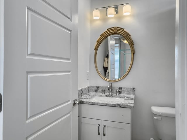 half bathroom with vanity and toilet