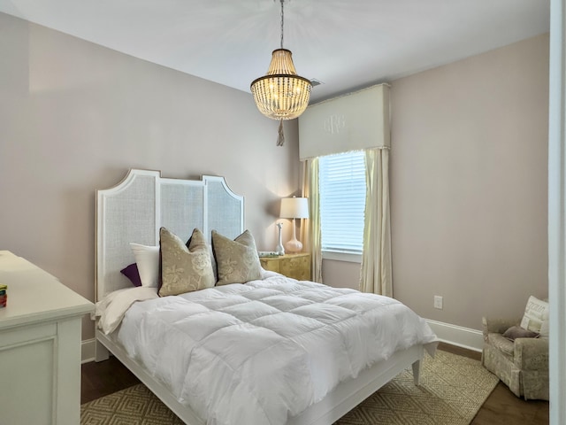 bedroom with an inviting chandelier, baseboards, and dark wood-style floors