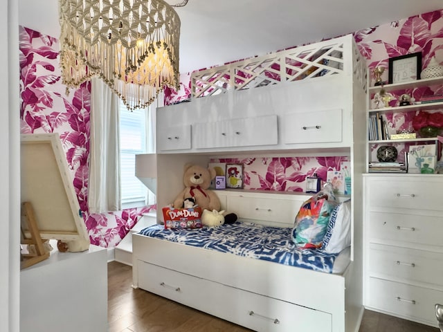 bedroom featuring wood finished floors and a chandelier