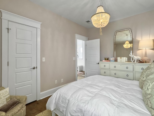bedroom featuring baseboards, dark wood-type flooring, a chandelier, and visible vents