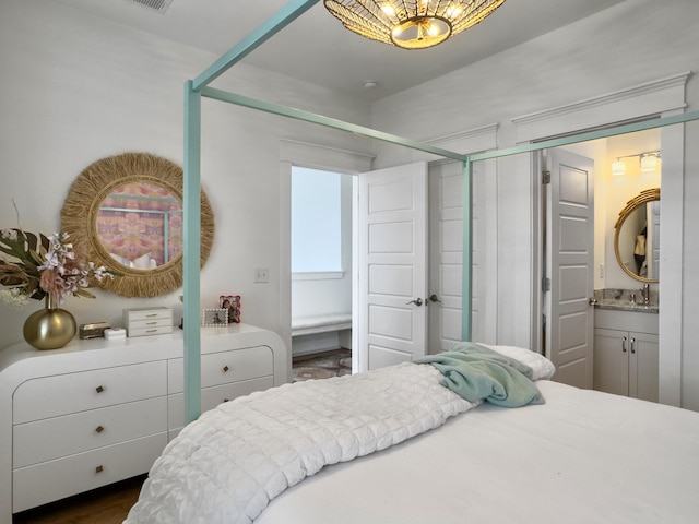 bedroom featuring a sink, an inviting chandelier, and a closet