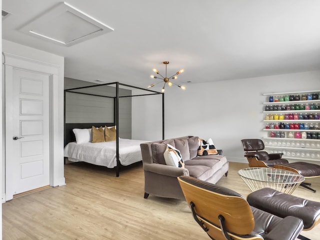 bedroom with light wood finished floors and attic access