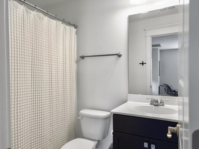 full bathroom with vanity, a shower with shower curtain, visible vents, and toilet
