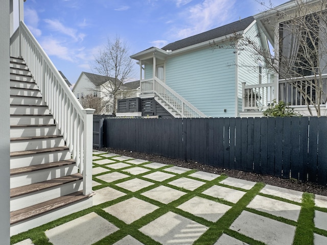 view of yard featuring a patio, fence private yard, and stairs
