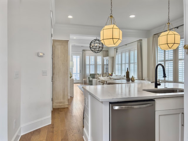 kitchen featuring stainless steel dishwasher, crown molding, pendant lighting, and a sink