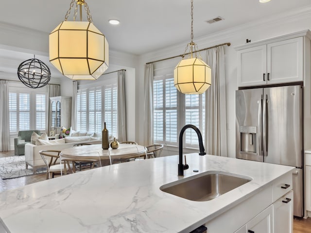 kitchen featuring visible vents, a wealth of natural light, a sink, and stainless steel fridge with ice dispenser