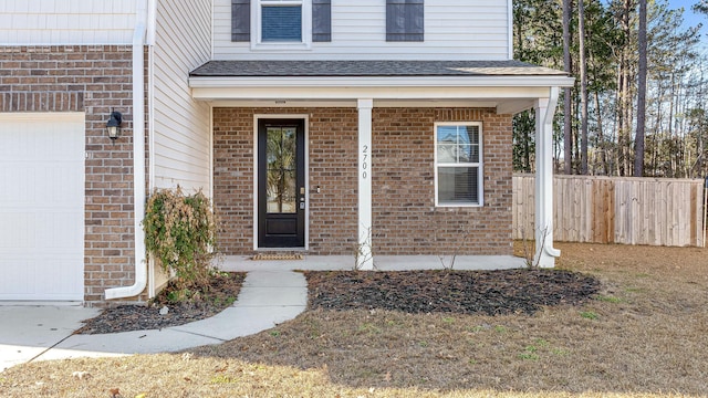 property entrance featuring covered porch and a garage