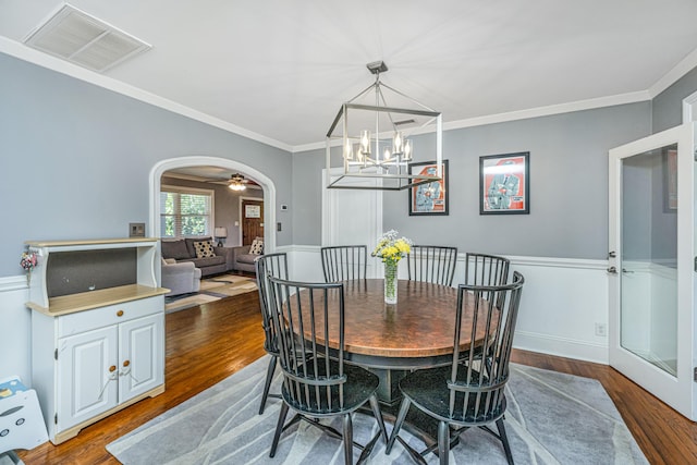 dining space featuring dark hardwood / wood-style flooring, a notable chandelier, and ornamental molding