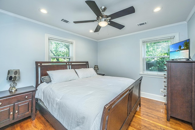 bedroom with ceiling fan, ornamental molding, light hardwood / wood-style floors, and multiple windows