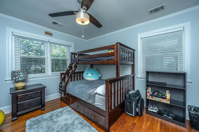 bedroom featuring crown molding, dark wood-type flooring, and ceiling fan