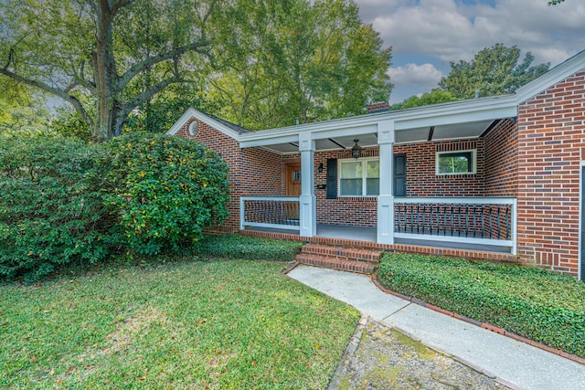 property entrance with a yard and covered porch