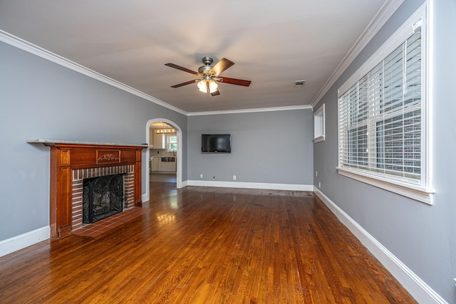 unfurnished living room with crown molding, ceiling fan, hardwood / wood-style floors, and a brick fireplace