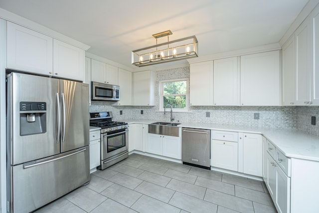 kitchen featuring pendant lighting, sink, stainless steel appliances, tasteful backsplash, and white cabinets