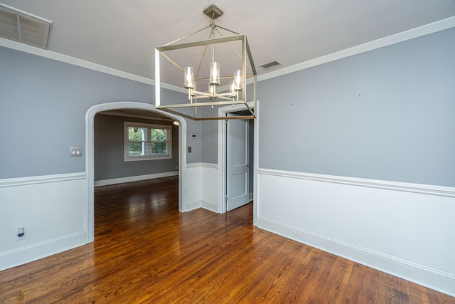 unfurnished dining area featuring ornamental molding, dark hardwood / wood-style floors, and an inviting chandelier