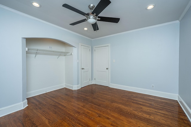 unfurnished bedroom featuring dark wood-type flooring, ceiling fan, crown molding, and a closet