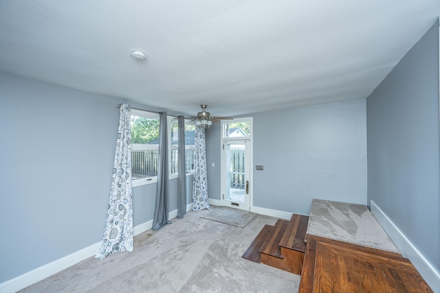 interior space with light carpet and ceiling fan