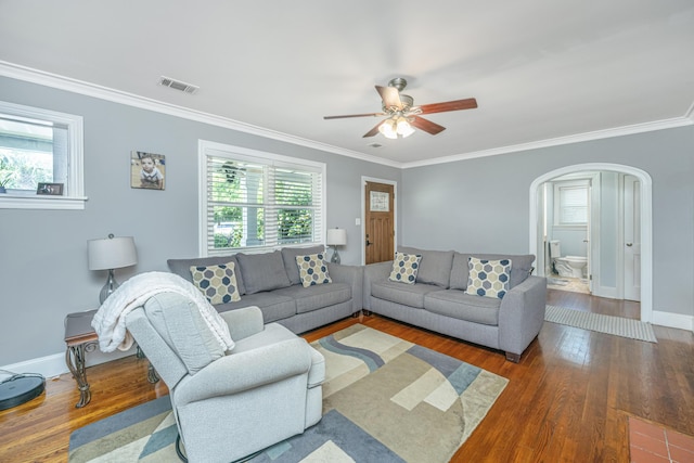 living room with crown molding, dark wood-type flooring, and ceiling fan