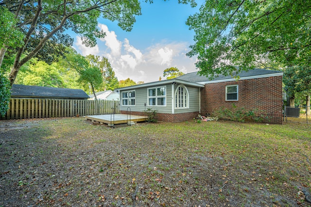 rear view of house with a wooden deck, a lawn, and central air condition unit