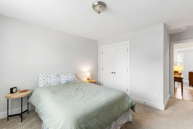 carpeted bedroom featuring a closet and baseboards