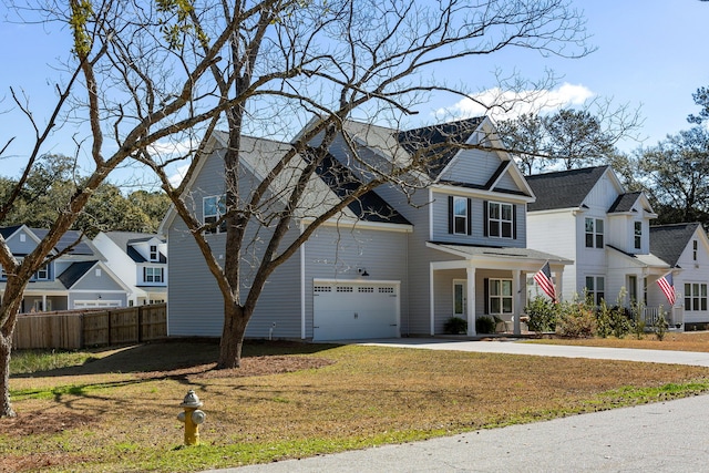 traditional-style home with driveway, covered porch, a residential view, and fence