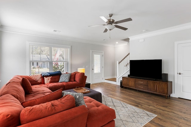 living room with a ceiling fan, visible vents, stairs, dark wood finished floors, and crown molding