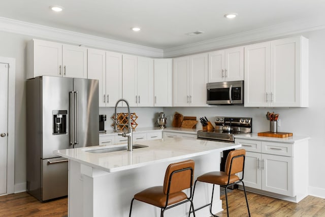 kitchen featuring stainless steel appliances, wood finished floors, and white cabinets