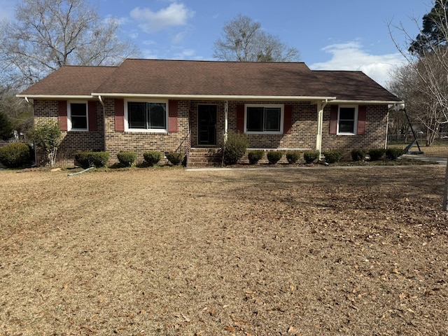 single story home with brick siding and a front yard