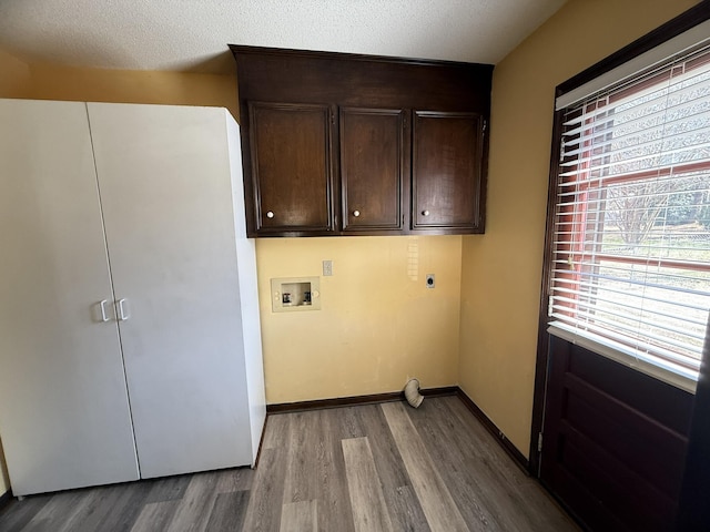 laundry room with hookup for a washing machine, cabinet space, light wood-style flooring, electric dryer hookup, and baseboards