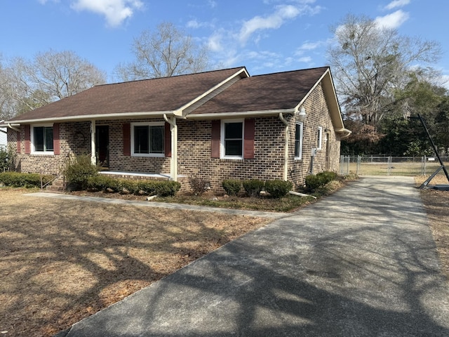 view of front of house with fence, a porch, and brick siding